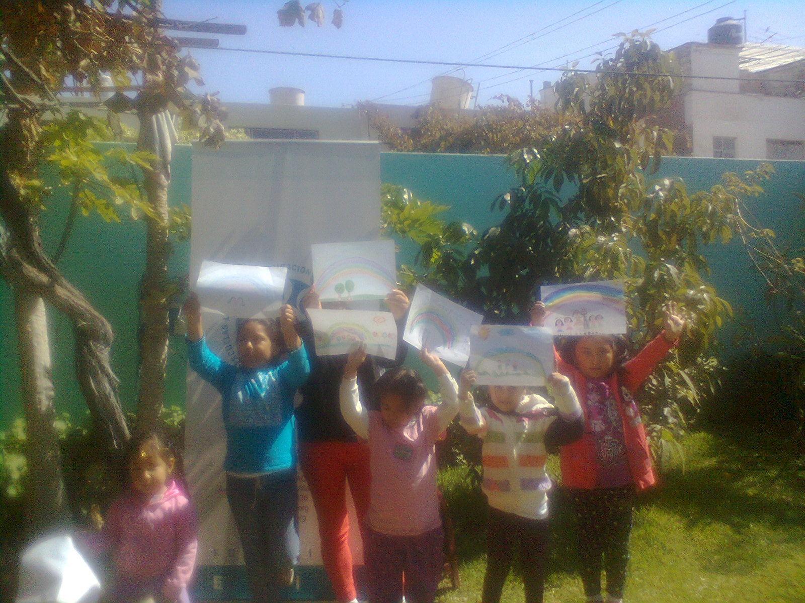 NIÑAS MOSTRANDO DIBUJOS DE LARCO IRIS